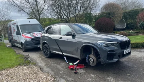 Mobile Tyre Solutions fitter replacing tyre on grey BMW X5 at customer's home in Oldham